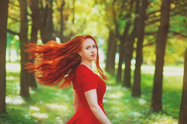 Schöne Frau mit roten flatternden Haaren — Stockfoto