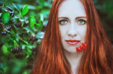 Kızıl saçlı kadın kırmızı çilek ile