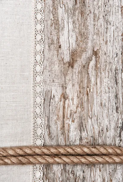 Linen fabric with lace and rope on the old wood — Stock Photo, Image