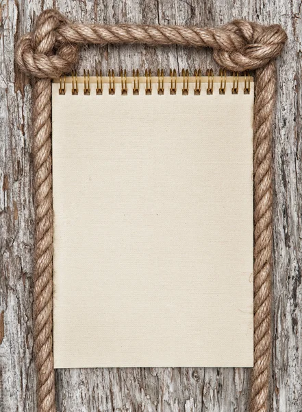 Touw, papier spiraal notebook en hout achtergrond — Stockfoto