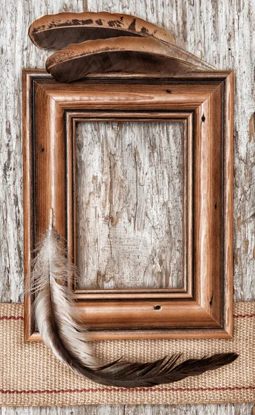 Holzrahmen, Klebeband und Federn auf altem Holz — Stockfoto