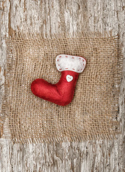 Red sock with the burlap textile on the old wood — Stock Photo, Image