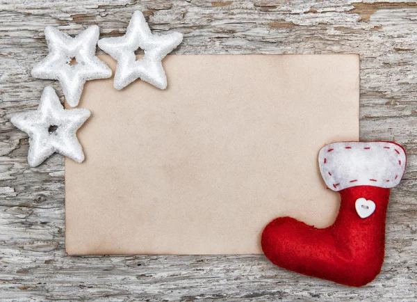 Christmas card with sheet of paper and red sock — Stock Photo, Image