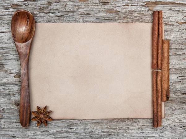 Sheet of paper, wooden spoon and spices — Stock Photo, Image