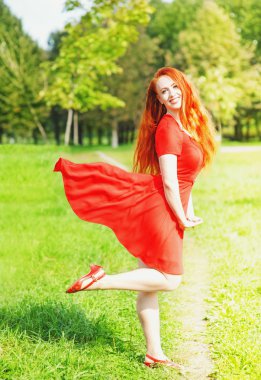 Kırmızı elbise çırpınan olan Kızıl saçlı kadın