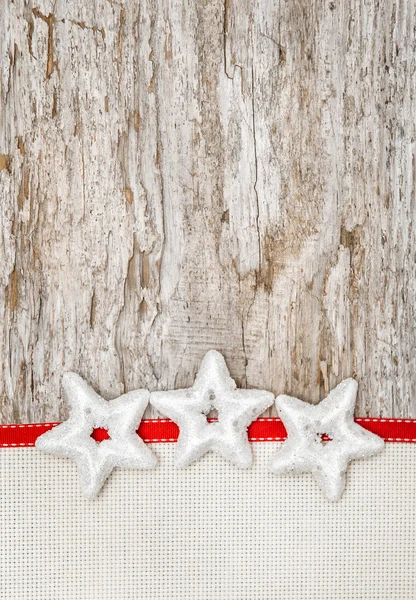 Decoración navideña con estrellas, cinta roja y lienzo —  Fotos de Stock