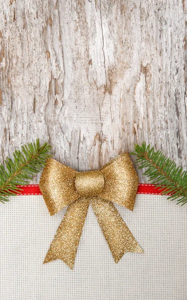 Tarjeta navideña con lazo, cinta y ramas de abeto —  Fotos de Stock