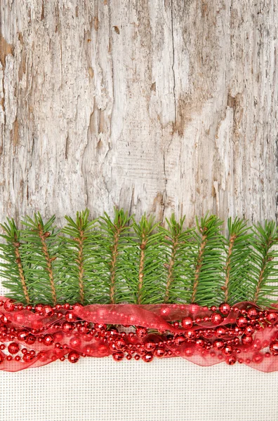 Decorazione natalizia con ghirlanda rossa, tela e ramo di abete — Foto Stock