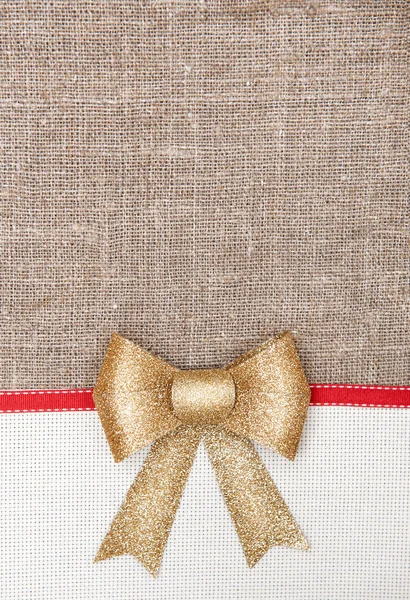 Christmas card with canvas, red ribbon on burlap — Stock Photo, Image