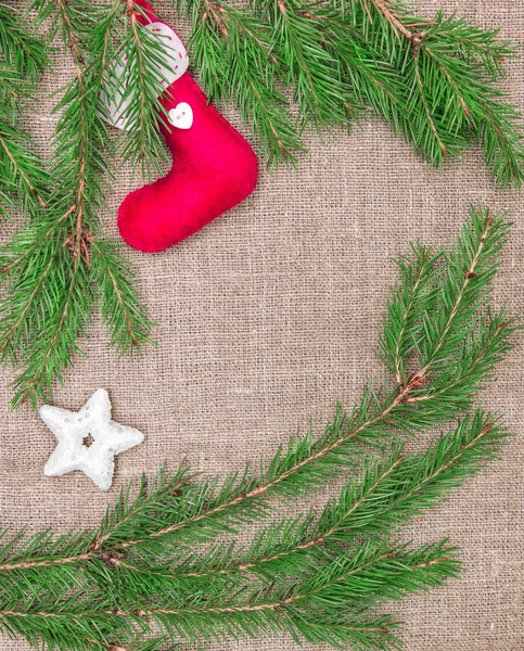 Χριστούγεννα διακόσμηση με τα κλαδιά του ελάτου και κόκκινης κάλτσας στο λινάτσα — Φωτογραφία Αρχείου