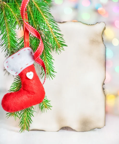 Weihnachtskarte mit roter Socke auf Tannenzweig — Stockfoto