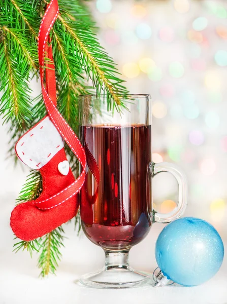 Weihnachtsglühwein und rote Socke auf Tannenzweig — Stockfoto