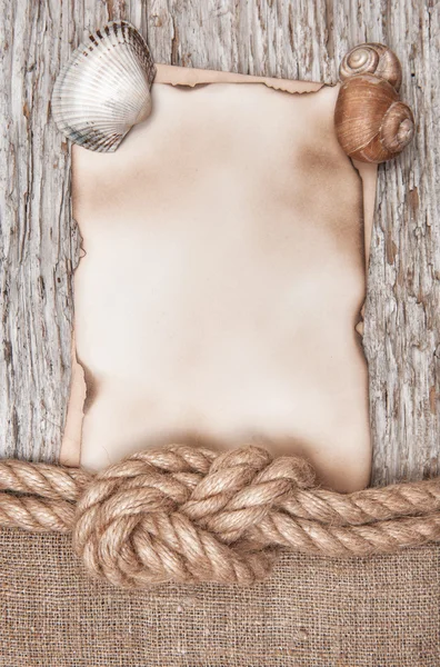 Aged paper with ship rope and seashells on the old wood — Stock Photo, Image