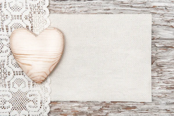 Wooden heart, lacy cloth and canvas on old wood — Stock Photo, Image