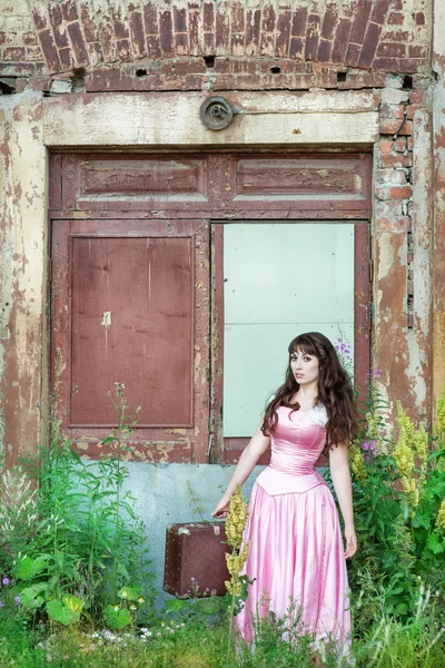 Женщина в винтажном платье со старым чемоданом — стоковое фото