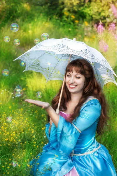 Lachende vrouw in middeleeuwse kleding en zeepbel ventilatoren — Stockfoto