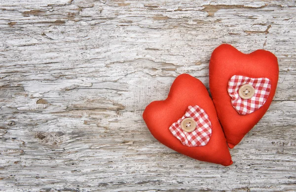 Valentinshintergrund mit textilen Herzen auf altem Holz — Stockfoto