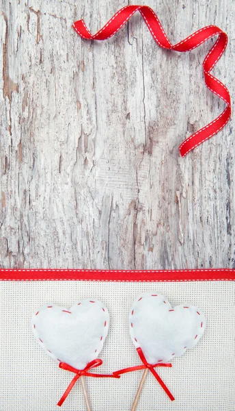 Valentinskarte mit textilen Herzen auf Leinwand und altem Holz — Stockfoto