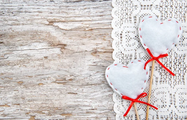 Valentine card with textile hearts on lacy cloth and old wood — Stock Photo, Image