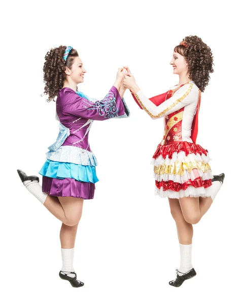 Two young women in irish dance dresses dancing isolated — Stock Photo, Image