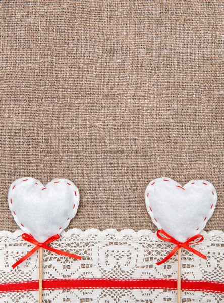 Textile hearts and lacy cloth on the burlap — Stock Photo, Image