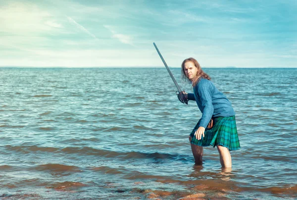 Brave man with sword in scottish costume — Stock Photo, Image