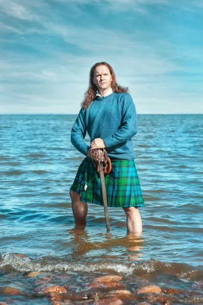 Brave man with sword in scottish costume — Stock Photo, Image