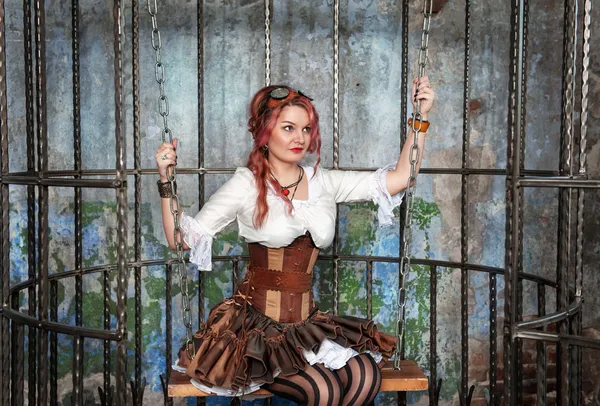 Beautiful steampunk woman in the cage — Stock Photo, Image