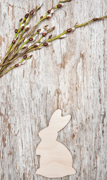 Pasen decoratie met houten konijn en bloeiwijzen op oud hout — Stockfoto