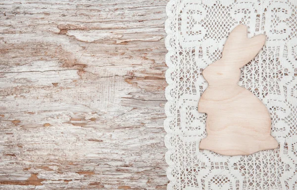 Пасхальное украшение деревянным кроликом и кружевной тканью на старом дереве — стоковое фото