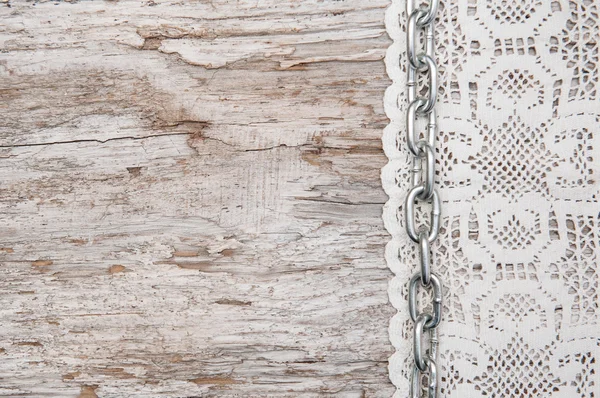 Tissu en dentelle avec chaîne sur le vieux bois — Photo