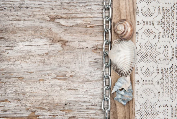 Tela de encaje con cadena y conchas marinas en la madera vieja — Foto de Stock