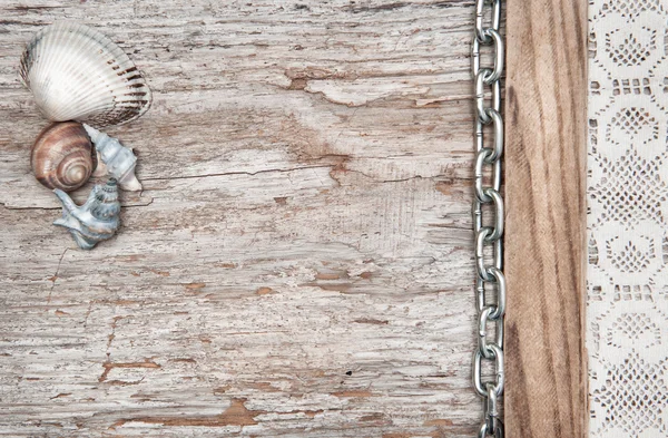 Tecido de renda com corrente e conchas na madeira velha — Fotografia de Stock