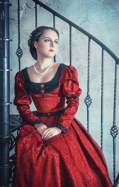 Krásná žena v středověkých šatech na schodišti — Stock fotografie