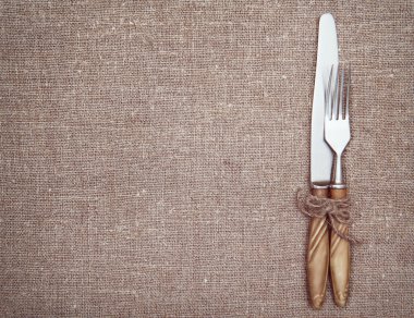 Çatal, bıçak ve eski kağıt üzerine çuval bezi