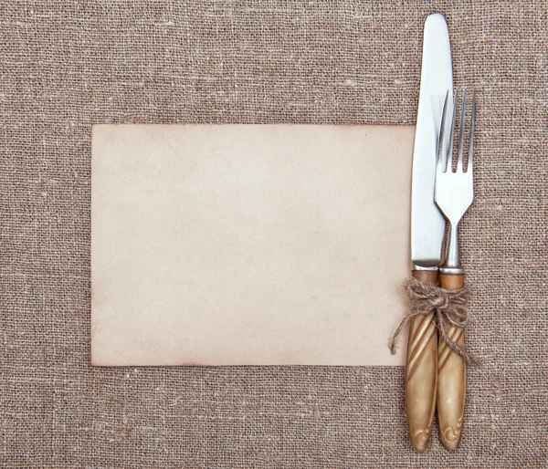 Gaffel, kniv och gamla papper på säckväv — Stockfoto