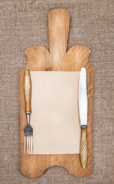 Staré kuchyně deska s věku papíru, vidlička a nůž — Stock fotografie