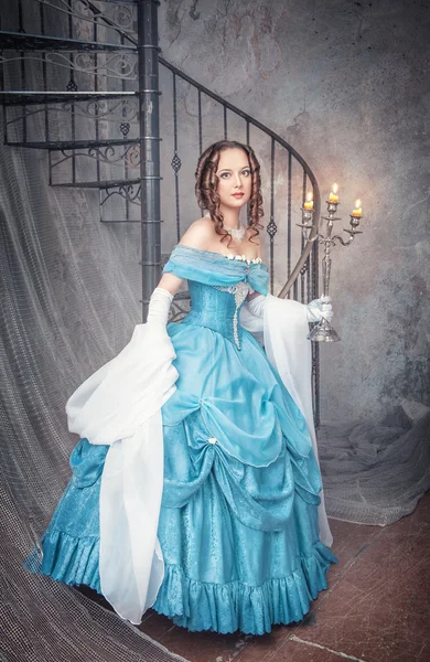 Beautiful woman in blue medieval dress with candelabrum — Stock Photo, Image