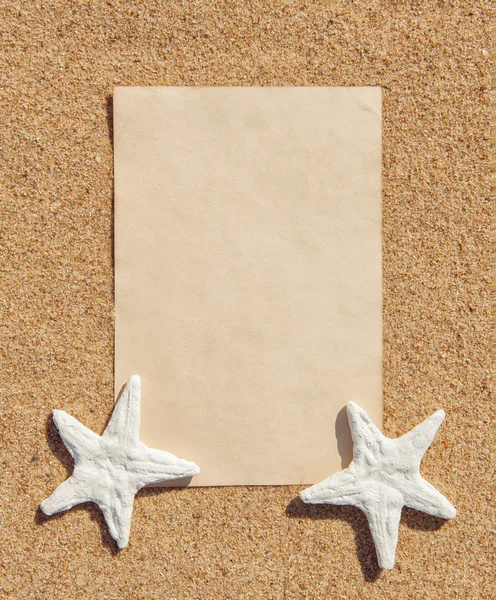 Лист бумаги и ракушки на песке — стоковое фото