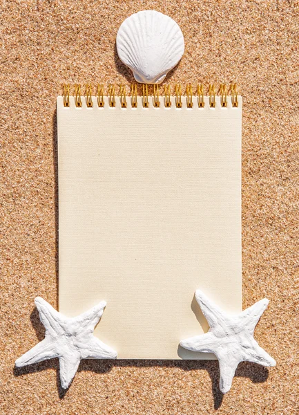 Sheet of paper and seashells on the sand — Stock Photo, Image