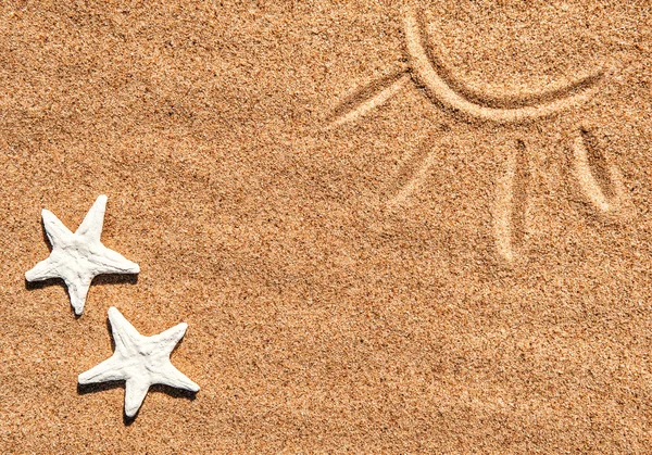 Seashells and picture of sun on the sand — Stock Photo, Image