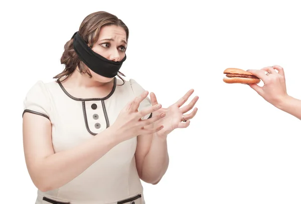 Plus size woman gagged stretching hands to hamburger — Stock Photo, Image