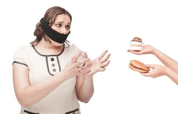 Plus grootte vrouw mond gesnoerd uitrekkende handen aan junkfood — Stockfoto