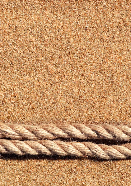 Песчаный фон с веревкой — стоковое фото