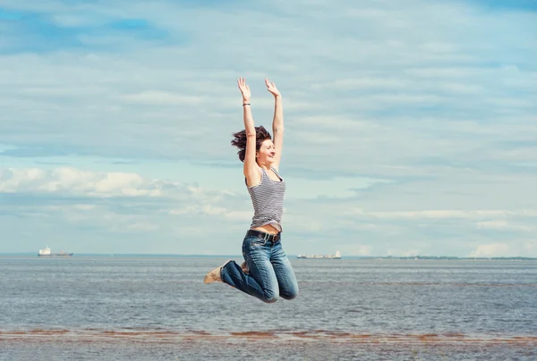 Glückliche Frau springt auf den Strand — Stockfoto