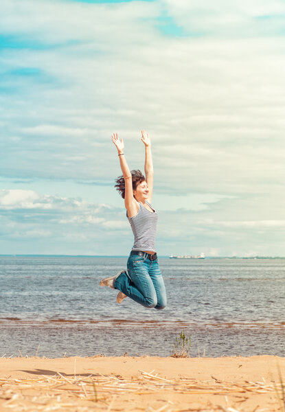 Happy woman jumping on the beach