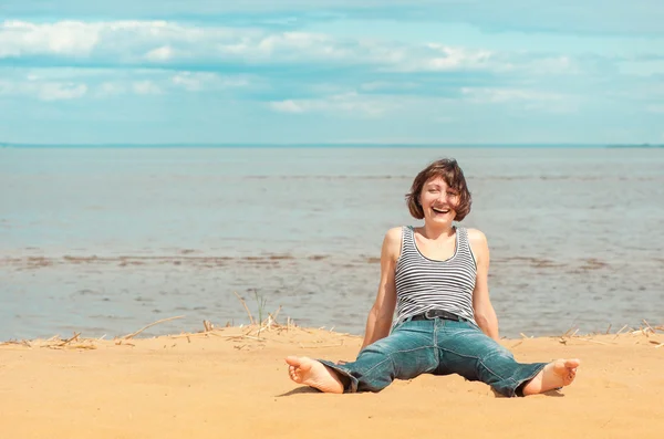 Sahilde oturup mutlu bir kadın — Stok fotoğraf