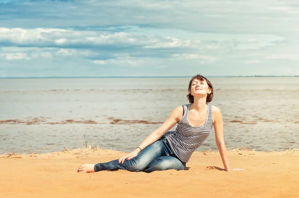 Женщина наслаждается солнечным светом на пляже — стоковое фото