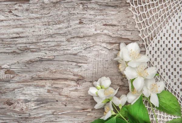 Flores brancas em tecido de renda e madeira velha — Fotografia de Stock