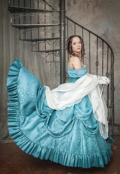 Schöne Frau im flatternden mittelalterlichen Kleid auf der Treppe — Stockfoto